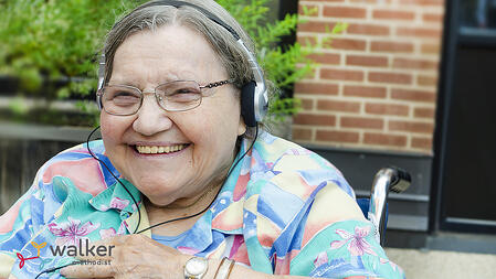 Beverly-Elderly woman wearing headphones and smiling while listening to music