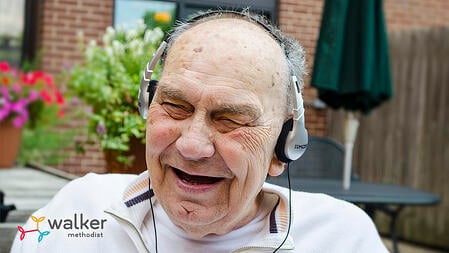 Les--elderly man wearing headphones and smiling while listening to music