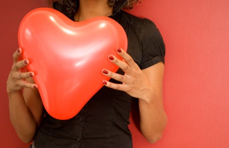 women holding heart balloon