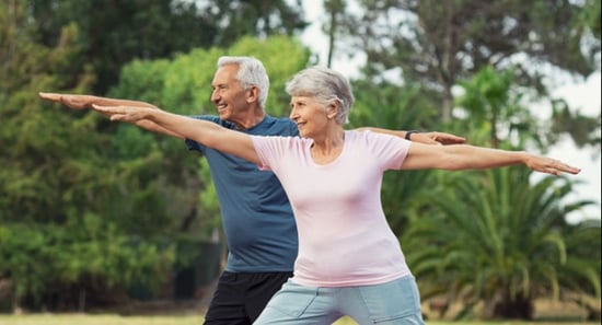 senior couple doing yoga outside