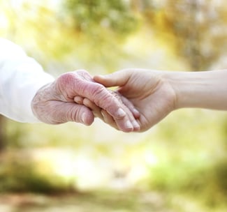 young hand holding an older hand